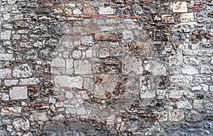 Wall from old gray bricks and stone as an abstract background