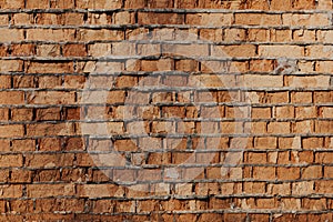 Wall of old orange clay bricks. Ruined vintage stone background. Rough aged masonry backdrop. Surface of grunge brick