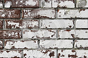 Wall from old and peeling brick, full frame use for background. Shabby and faded white paint on a brick wall