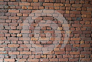 Wall of old red brick with a pronounced relief.