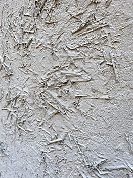 Wall painted with white paint. White wall is painted with hay and rice straw. Abstract background with old white plaster