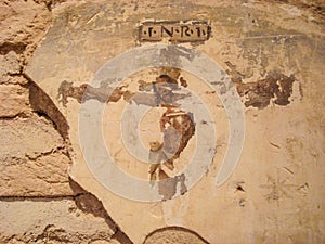 Wall painting of Christ on the cross. You can see the image but with deterioration that gives it a touch of mysticism for