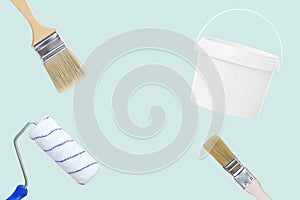 Wall painting set. Paint bucket, paint roller brushes. Blue background