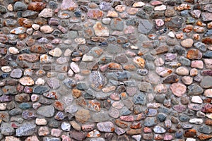 Wall of pebbles and cement background