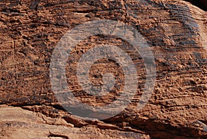 Wall of petroglyphs on red sandstone