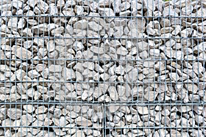 Wall of pile of stones in a grillage