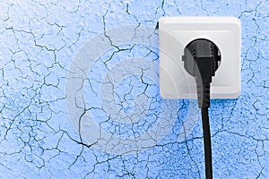 Wall plug socket on cracked wall