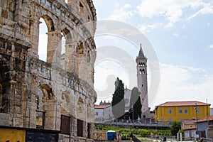 Wall of the Pula Arena, the only remaining Roman amphitheatre entirely preserved, with the tower of the Church of St Anthony at