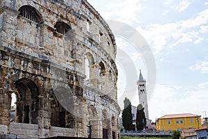 Wall of the Pula Arena, the only remaining Roman amphitheatre entirely preserved, with the tower of the Church of St Anthony at