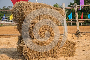 A wall of rectangular bales of straw stacked in a field before b
