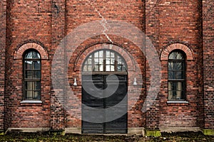 Wall of red bricks and old metal industrial doors