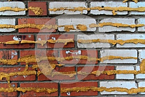 Wall of red and white bricks with Spray foam