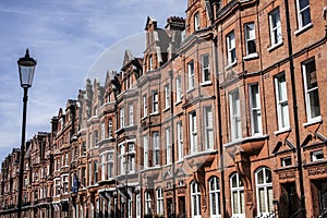 A wall of redbricked houses in London and the lamp post.