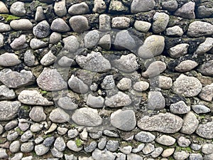 Wall of river stones as a texture. Old stone wall background photo