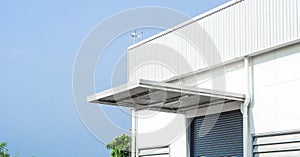 Wall, roof and shutter door of Factory or warehouse building in industrial estate with blue sky and copy space