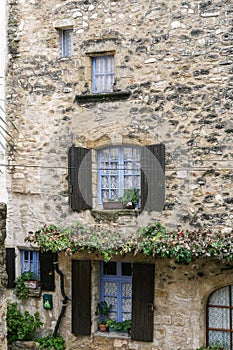 The wall of rough stone with windows of different sizes.