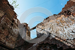 Wall of ruined house at sky background, old building demolished by earthquake or other natural disaster
