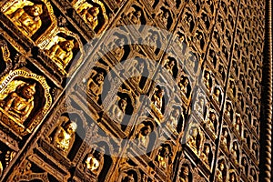 A wall of sculpted buddha images on wood, some covered with gold leaf, at Pindaya cave in Myanmar.