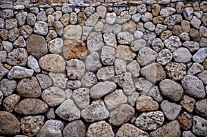 Wall of sea stones. Gray and yellowish, textured stone.