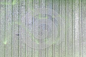 Wall of sheet metal. Blank background with colored green overflows. Texture of corrugated metal.