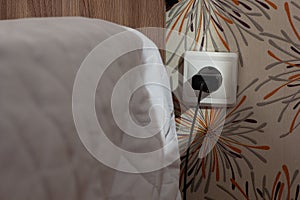 Wall socket with charger plug inside close to bed