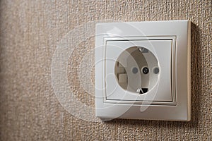 Wall socket, white electric socket on wallpaper background