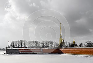 The wall and spire of the Petropavlovsk Fortress over the frozen Neva River in St. Petersburg, Russia