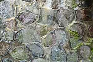 Wall of stone overgrown with moss