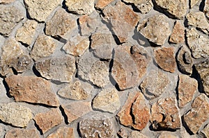 A wall of stones. Granite. Masonry. Clay tiles.