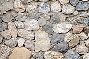 The wall of stones monotonous color of different sizes and shapes
