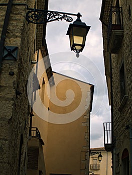 wall street lamp on a narrow street in Italy. A typical narrow street in a historic city