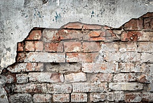 Wall texture background, rough damaged stucco or plaster over old brickwork. Dirty brick wall of building, fragment of vintage