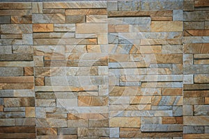 Wall tiles patterned like natural split stone background. Simulated yellow natural stone facade, wall tiles texture.