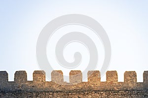 Wall of the tower of a medieval castle in backlight