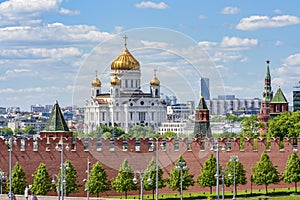 Wall and towers of Moscow Kremlin with Cathedral of Christ the Savior Khram Khrista Spasitelya at background, Russia