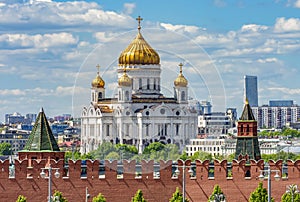 Wall and towers of Moscow Kremlin with Cathedral of Christ the Savior (Khram Khrista Spasitelya) at background, Russia