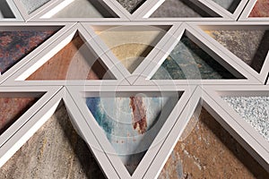 Wall with triangles of different materials in white frames
