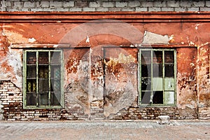 Wall with two broken windows of abandoned building in Mariupol