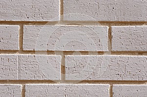 Wall of white bricks with yellow fugue