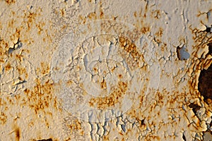 The wall is white with cracked paint, rusty metal and bullet holes. Creative vintage background.