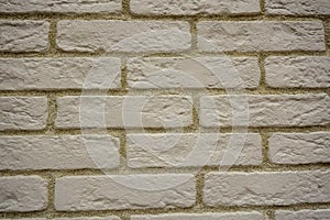 Wall of white uneven bricks with a yellowish seam.