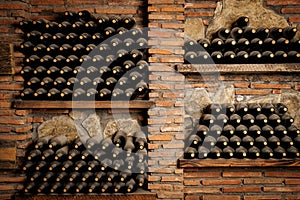 A wall of wine bottles with a brick background