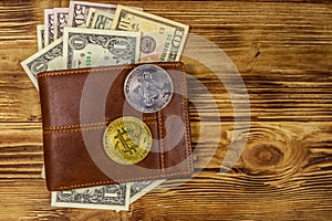 Wallet with american dollars bills and bitcoins on wooden background