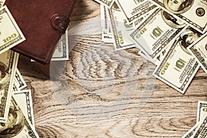 Wallet and banknotes of dollars on wooden background