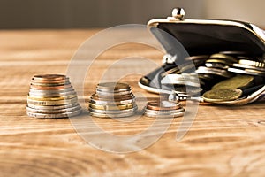 Wallet with coins on a wooden table. Close up. Selective focus. The concept of poverty