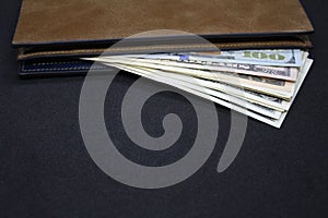 Wallet with dollars on a dark background