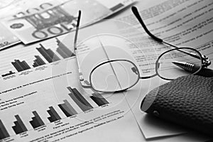 Wallet, 100 Euro banknote, glasses, pen and financial diagrams report. Profit and loss business concept