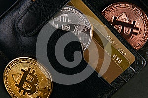 Wallet with golden bitcoins and bank credit cards