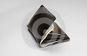 Wallet with a hundred dollar bill and credit cards on a gray background