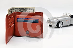 Wallet with US Dollars and blured old toy car background